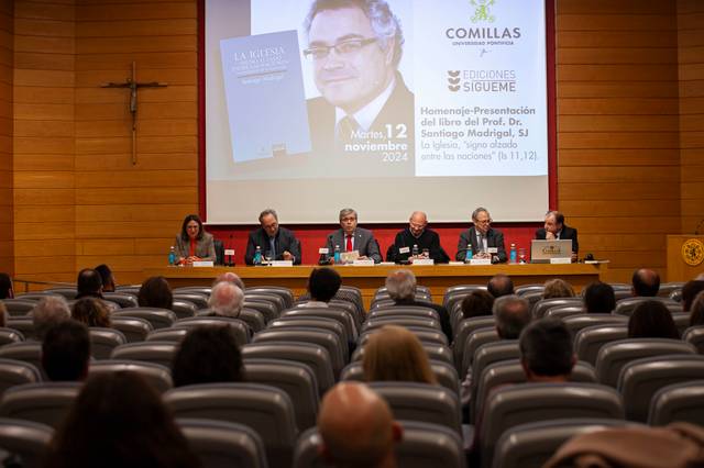 Presentación de un libro en un auditorio con cinco personas sentadas en un panel frente a una audiencia.