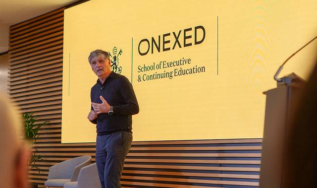 Un hombre está dando una conferencia en la escuela ejecutiva y de educación continua ONEXED.