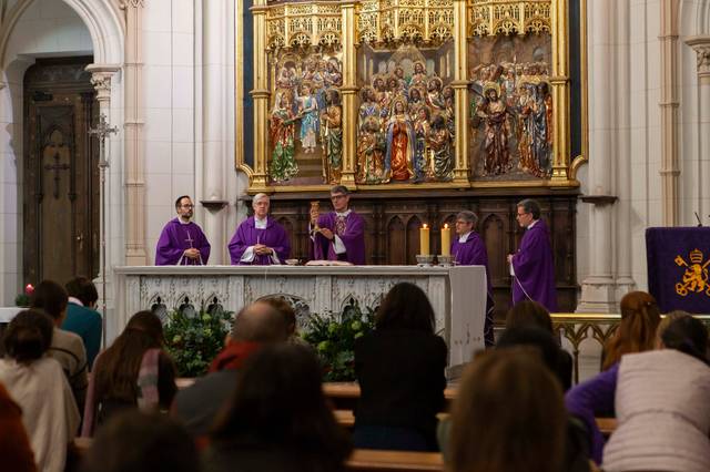 Sacerdotes realizando una misa en una iglesia decorada con ornamentos morados y un altar dorado en el fondo.