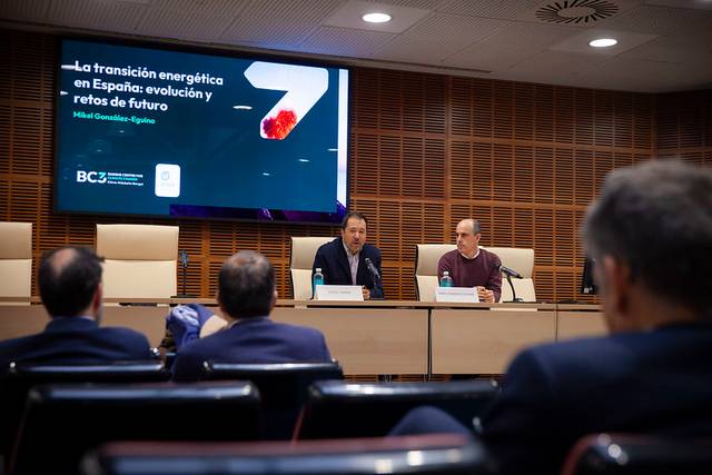 Dos hombres presentan en una conferencia sobre la transición energética en España frente a un público.