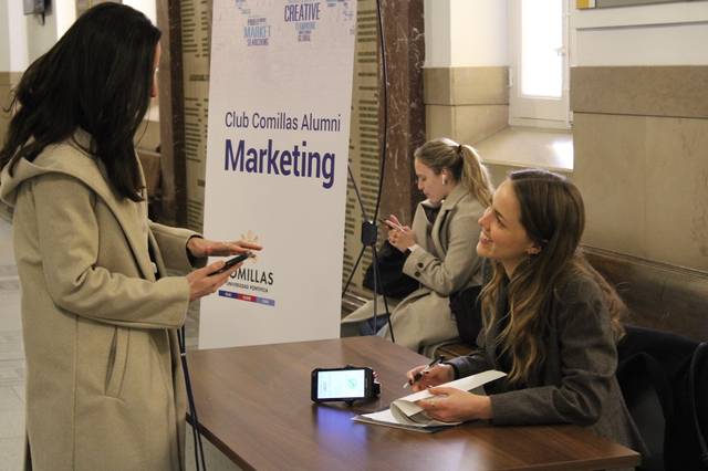 Una mujer conversa con otra en un evento de marketing del Club Comillas Alumni.