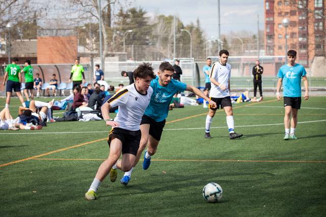 Dos jugadores de fútbol compiten por el balón en un campo de hierba.