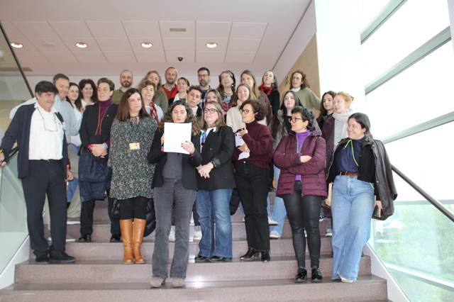 Un grupo de personas posando en una escalera dentro de un edificio.