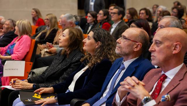 Un grupo de personas sentadas en un auditorio durante un evento, prestando atención al orador.