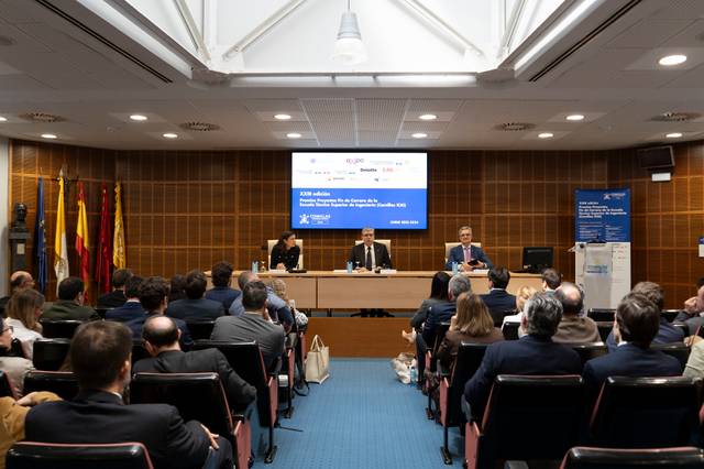 Una conferencia en un auditorio con un panel de ponentes y una audiencia atenta.