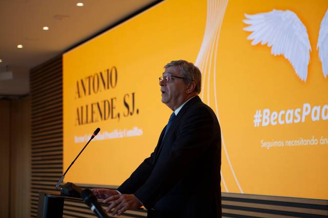 Una persona habla en un podio frente a una pantalla con un fondo naranja y el texto 'Antonio Allende, S.J.'