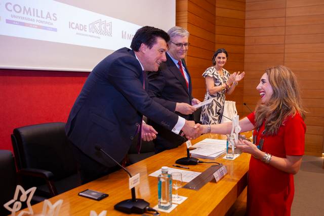 Un evento en el que se entregan premios, con personas sonriendo y aplaudiendo.