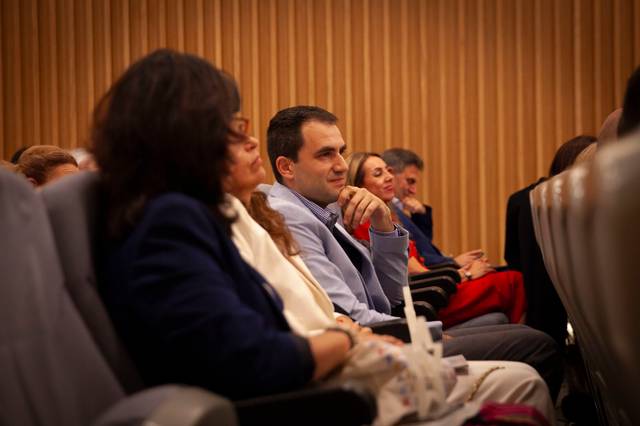 Un grupo de personas escuchando atentamente en un evento o conferencia.