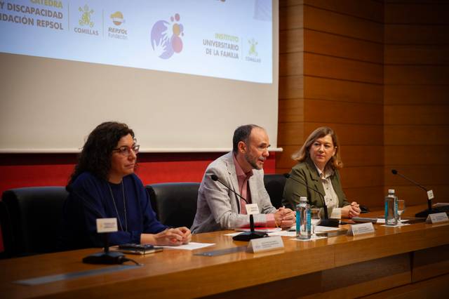 Un panel de discusión con tres personas sentadas en una mesa, en un evento relacionado con la inclusión y la discapacidad.