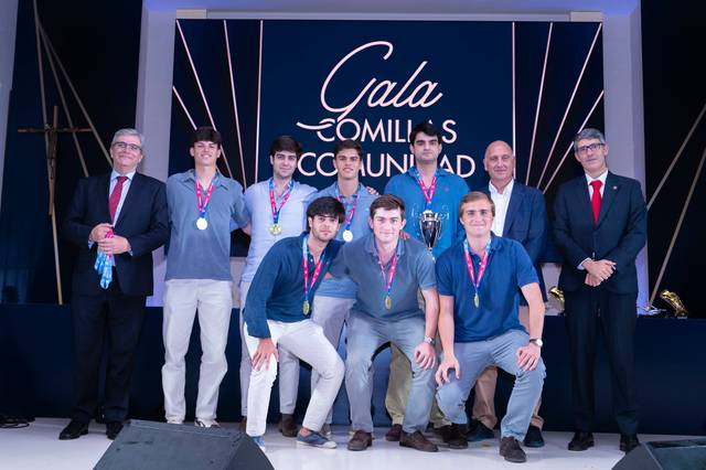 Un grupo de jóvenes posando con medallas en un evento formal.