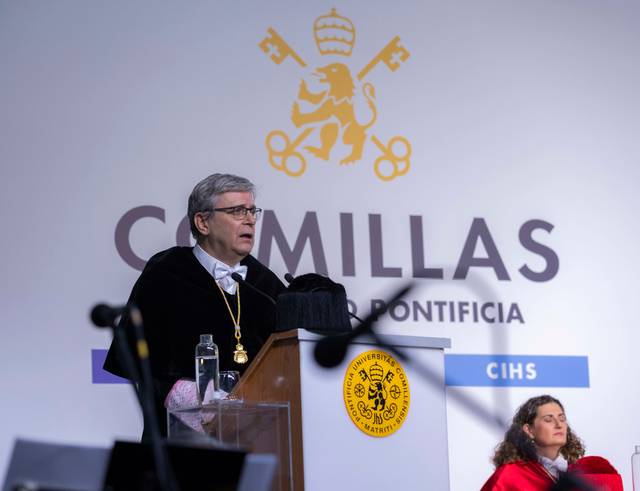 Un hombre con toga académica habla en un evento de graduación en la Universidad Pontificia Comillas.