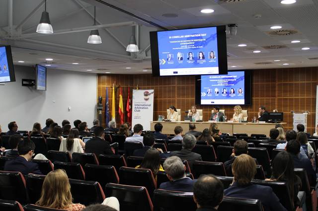 Una conferencia con varios ponentes en un auditorio lleno de público.