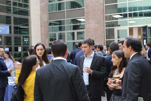 Un grupo de personas interactuando en un evento social al aire libre.