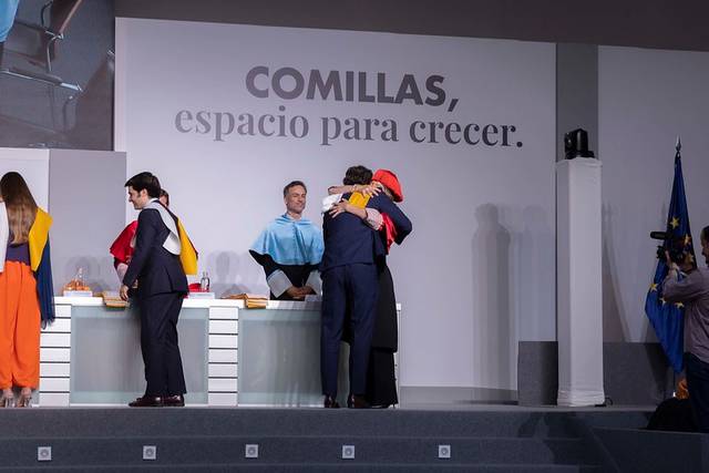 Una ceremonia académica donde los graduados se abrazan y celebran su logro en un ambiente festivo.