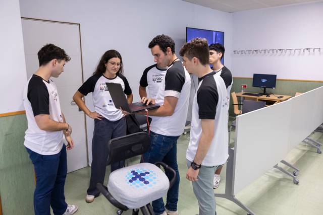 Un grupo de jóvenes está colaborando en un proyecto tecnológico en un entorno de trabajo moderno.