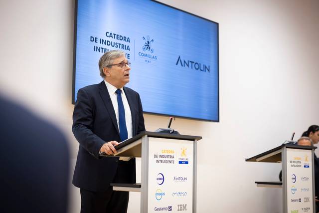 Un hombre habla frente a un podio durante un evento relacionado con la Cátedra de Industria Inteligente.
