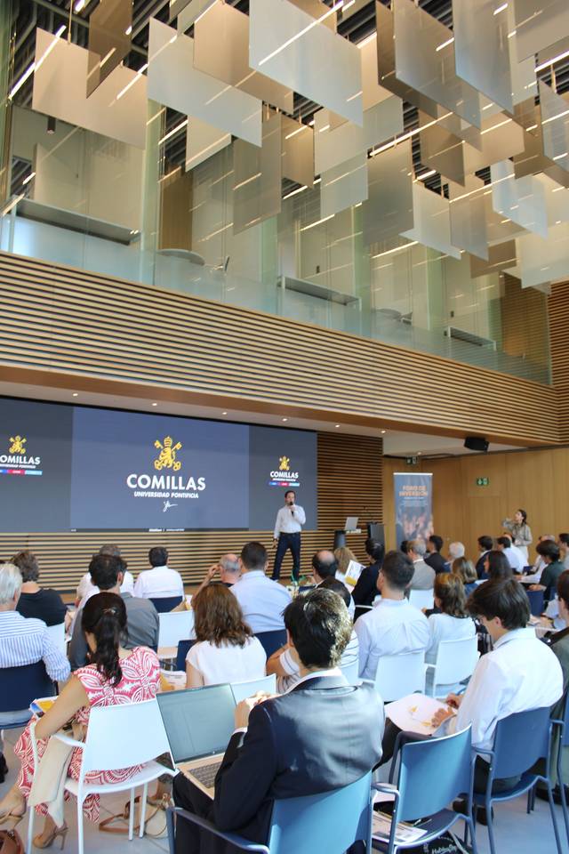 Una presentación en un auditorio moderno con un gran número de asistentes.