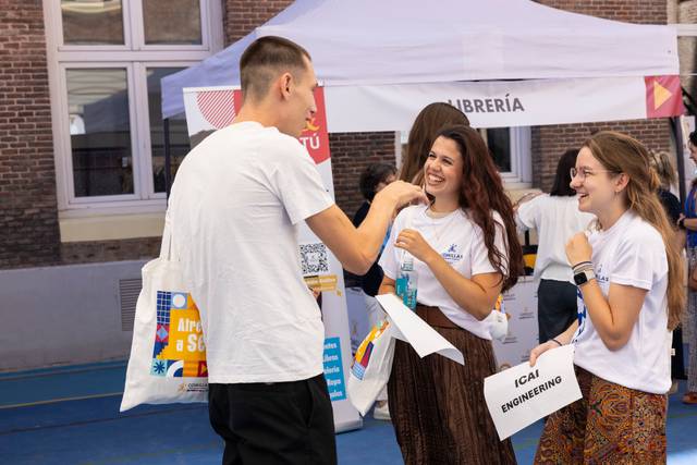 Un grupo de jóvenes interactúa en un evento de presentación de carreras universitarias.
