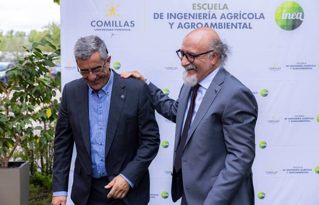 Dos hombres sonrientes interactúan durante un evento en la Escuela de Ingeniería Agrícola y Agroambiental de la Universidad Comillas.
