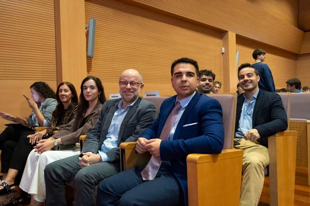 Grupo de personas sentadas en un auditorio durante un evento.