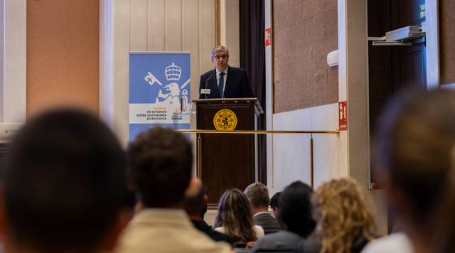 Un orador presenta un discurso en un evento sobre políticas públicas ante una audiencia.