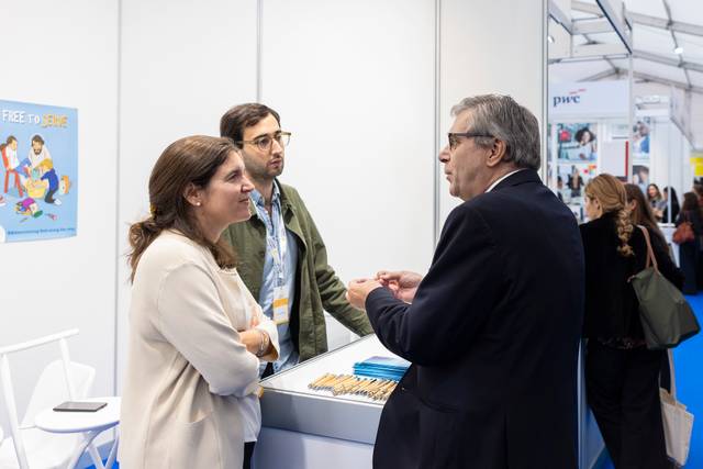Grupo de personas conversando en un evento o exposición.