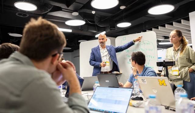 Un grupo de personas asiste a una presentación en una sala de clases moderna.