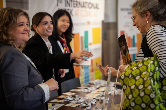 Un grupo de mujeres conversando en un evento internacional mientras se registran.