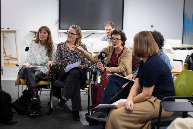 Un grupo de personas participan en una discusión en un entorno de oficina moderna.
