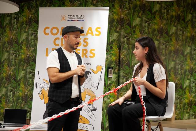 Dos personas interactúan durante una presentación en un ambiente creativo.