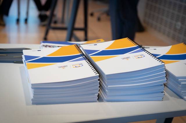 Una pila de cuadernos impresos en una mesa con un diseño de colores azul y amarillo.