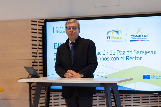 Un hombre de pie frente a un proyector, hablando sobre un evento relacionado con la paz de Sarajevo.