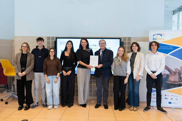 Un grupo de personas posando para una foto oficial con un documento en mano, en un contexto de presentación o firma de convenio.