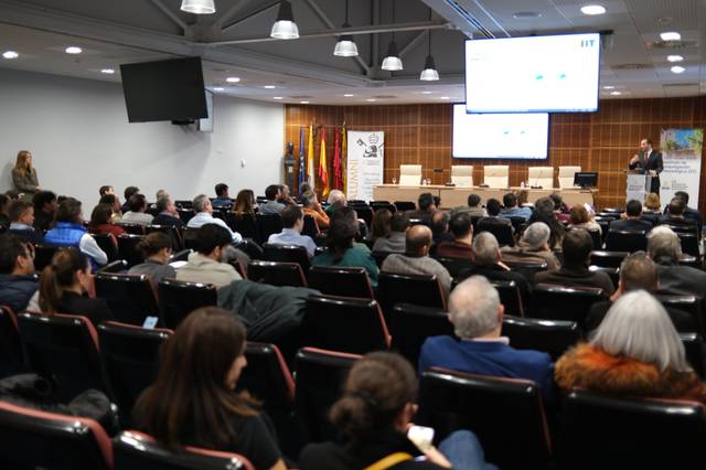 Un gran auditorio lleno de personas atendiendo a una presentación.