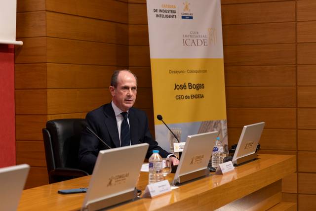 Un hombre sentado en una conferencia, hablando sobre temas relacionados con la industria inteligente.