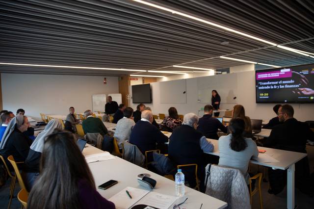 Un grupo de personas asiste a una presentación en un aula moderna.