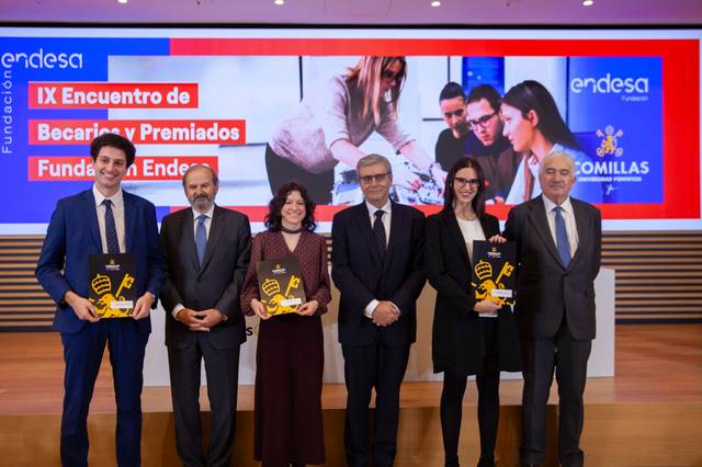 La imagen muestra a un grupo de personas en un evento de entrega de premios, posando con trofeos en un ambiente formal.
