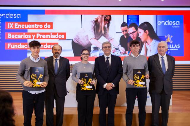 Un grupo de cuatro personas con certificados en un evento de becarios y premiados de la Fundación Endesa.