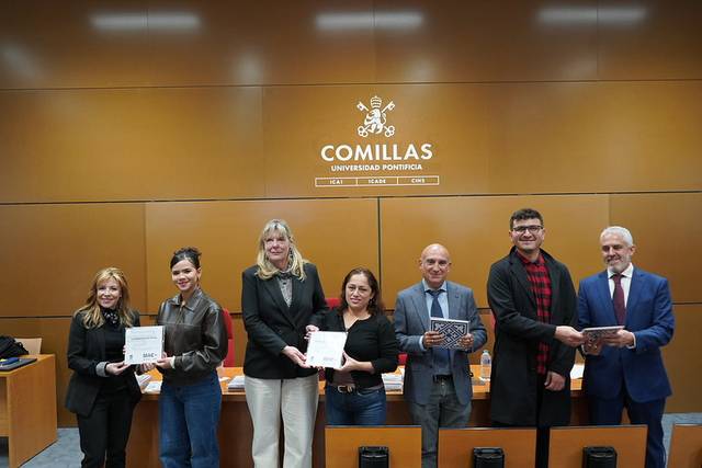 Un grupo de personas sosteniendo diplomas en un evento en la Universidad Pontificia Comillas.