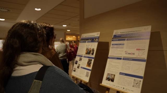Una persona observa atentamente pósters informativos en un evento.