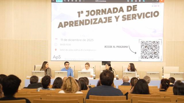 Una conferencia sobre el aprendizaje y servicio con varios panelistas en una sala llena de público.