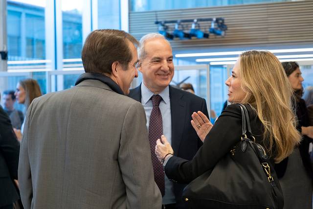 Un grupo de tres personas conversando en un evento social.