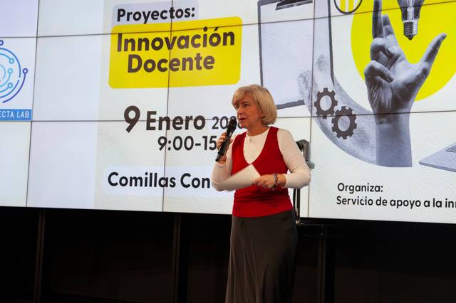 Una mujer habla en un evento sobre innovación docente en una presentación multimedia.