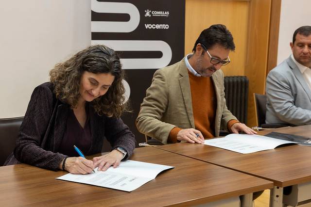 En la imagen se observa a tres personas durante un evento de firma de documentos en un entorno académico.