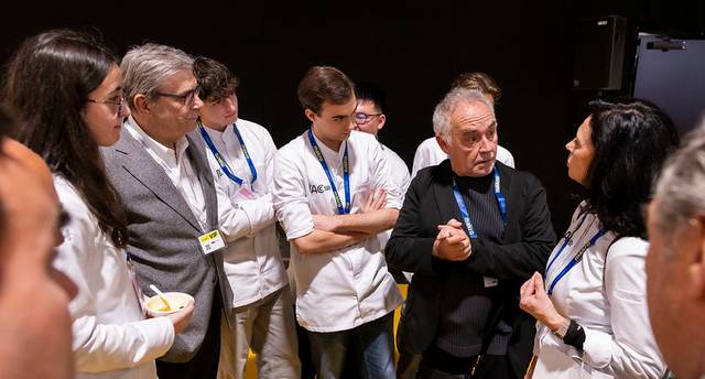 Un grupo de personas discutiendo en un evento, algunas vestidas con ropa de cocina.