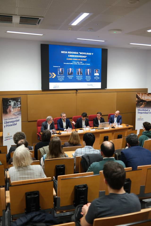 Una mesa redonda sobre movilidad y seguridad con varios ponentes en un salón lleno de público.