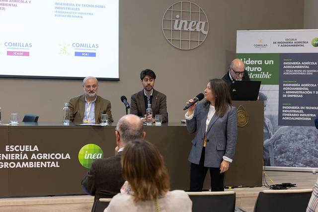 Una presentación en una conferencia sobre ingeniería agrícola, con varios ponentes en un escenario.