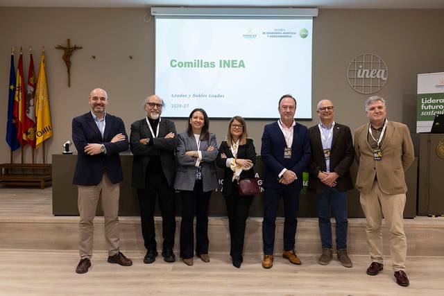 Un grupo de personas posando frente a una presentación en la que se muestra el nombre Comillas INEA.