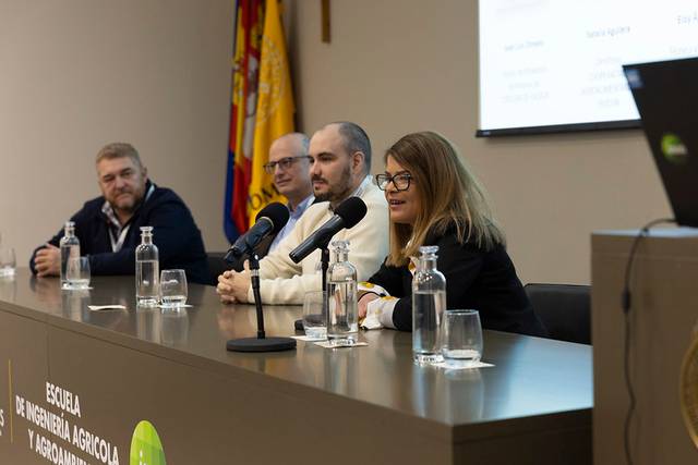 Cuatro personas sentadas detrás de una mesa en un evento en la Escuela de Ingeniería Agrícola y Agronomía.