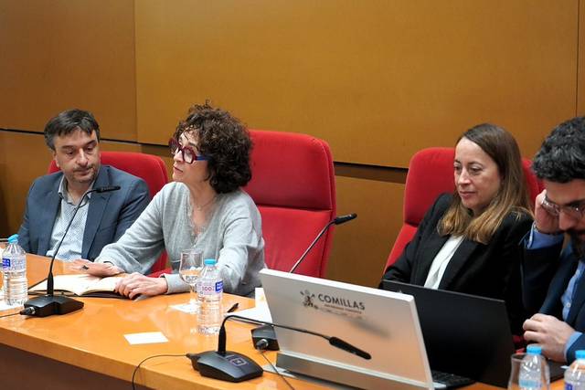 Un grupo de personas discutiendo en una mesa de conferencias.